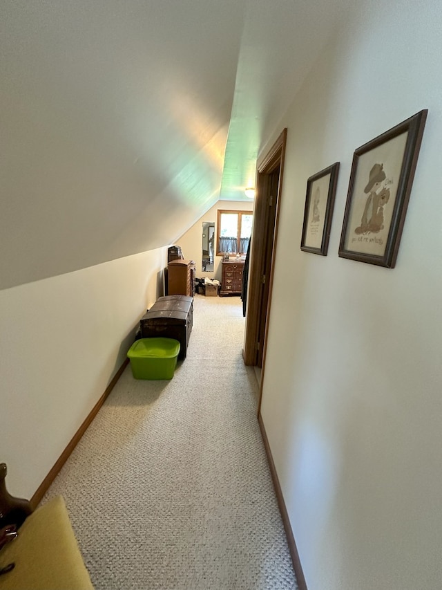 hall with carpet flooring and vaulted ceiling