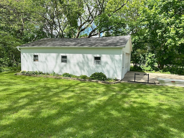 exterior space with a garage, an outdoor structure, and a yard