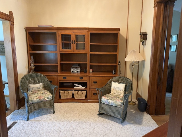 sitting room featuring decorative columns and carpet floors