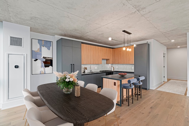 dining room with sink and light hardwood / wood-style floors