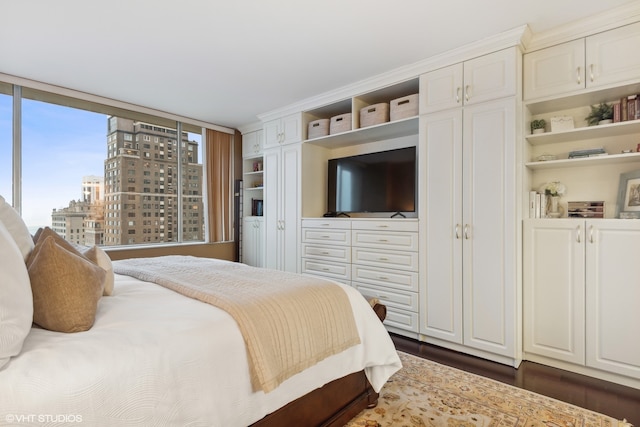 bedroom featuring a wall of windows and dark hardwood / wood-style flooring