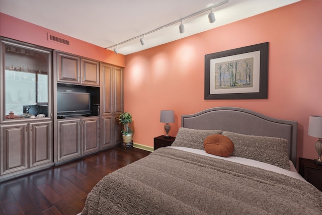 bedroom featuring dark wood-type flooring and track lighting