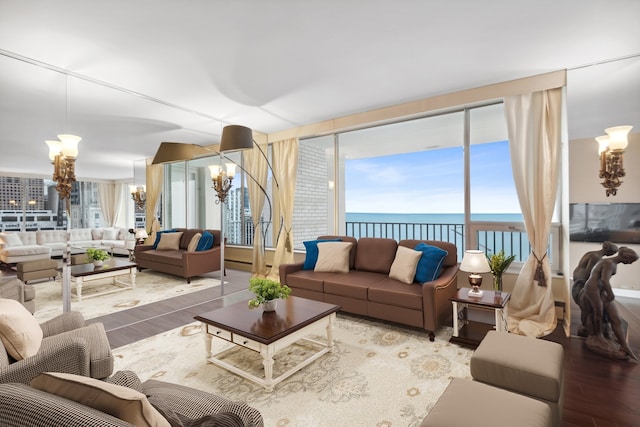 living room with an inviting chandelier, floor to ceiling windows, hardwood / wood-style flooring, and a water view