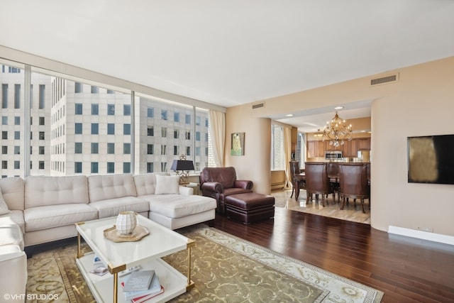 living room with a baseboard heating unit, a notable chandelier, and wood-type flooring