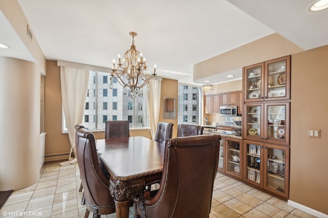 tiled dining space with baseboard heating and a chandelier