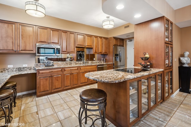 kitchen with stainless steel appliances, light stone counters, light tile flooring, and a breakfast bar