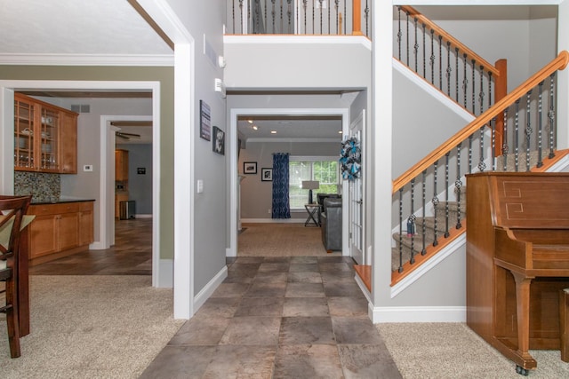 carpeted foyer with ornamental molding