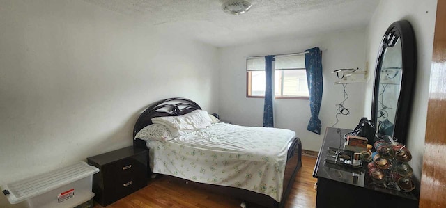 bedroom featuring a textured ceiling and hardwood / wood-style flooring