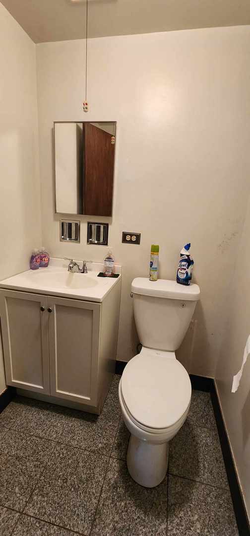 bathroom featuring tile flooring, toilet, and vanity