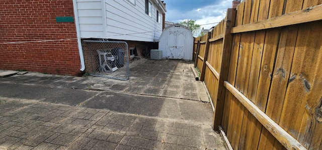 exterior space featuring central AC, a storage shed, and a patio area