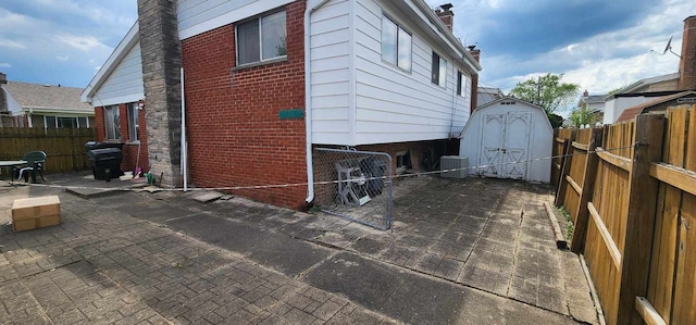 exterior space with a patio, a shed, and central air condition unit