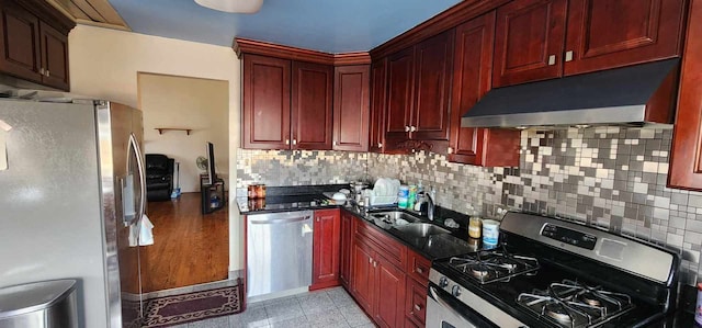 kitchen featuring sink, backsplash, light tile floors, and stainless steel appliances