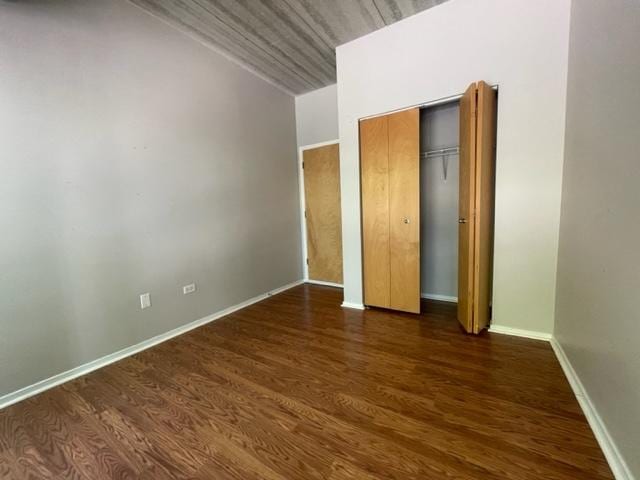 unfurnished bedroom with dark hardwood / wood-style floors and a closet