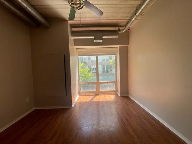 spare room with ceiling fan and dark wood-type flooring