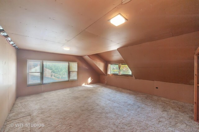 bonus room featuring vaulted ceiling and carpet flooring