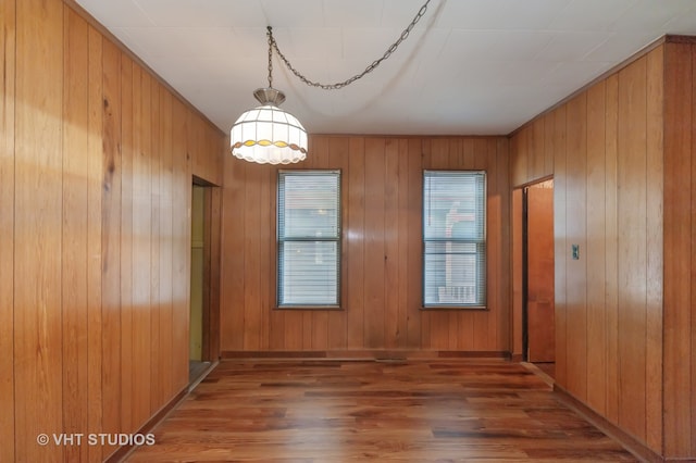 empty room with wooden walls and dark wood-type flooring