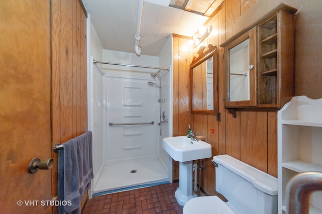 bathroom featuring a shower, wooden walls, and toilet