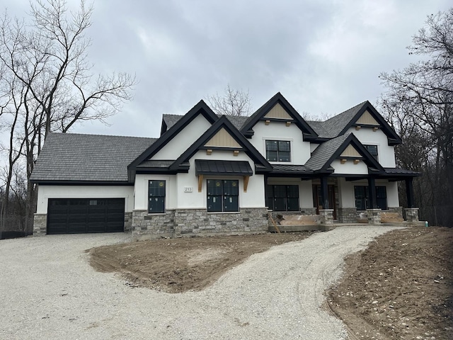 view of front of property with a garage, driveway, stone siding, and a porch