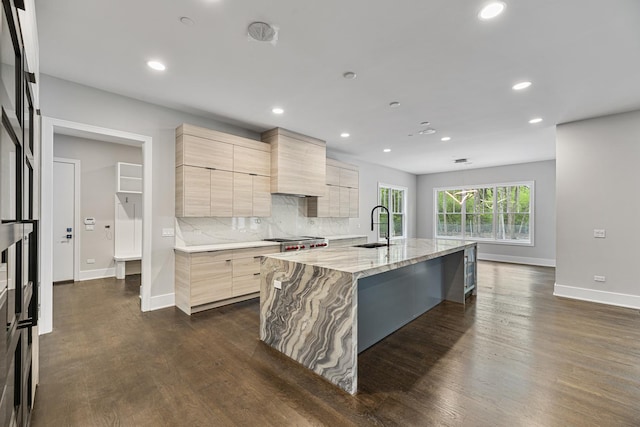 kitchen featuring a sink, baseboards, recessed lighting, modern cabinets, and light stone counters