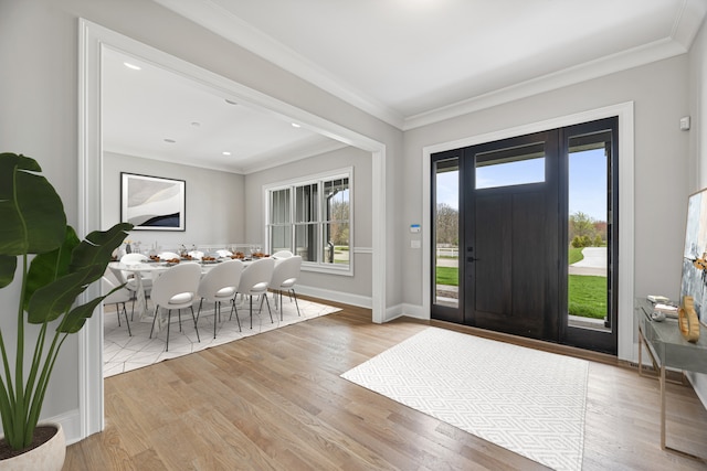 entryway featuring ornamental molding and light hardwood / wood-style flooring