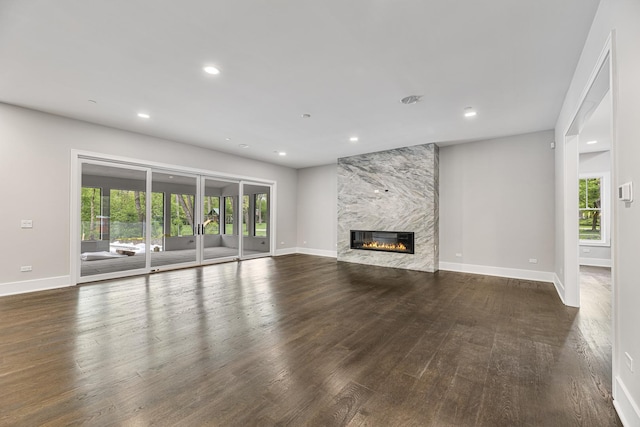unfurnished living room with a high end fireplace, baseboards, wood finished floors, and recessed lighting