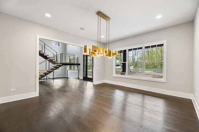 unfurnished dining area with stairway, baseboards, wood finished floors, and recessed lighting