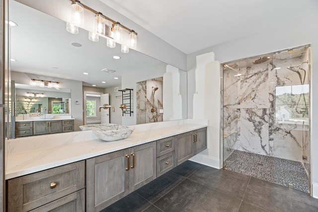 bathroom featuring vanity, tile patterned flooring, and tiled shower