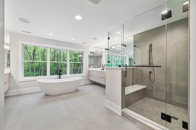 bathroom with concrete floors, independent shower and bath, and vanity