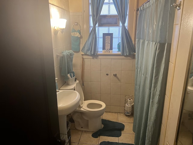 bathroom featuring tile flooring, toilet, and tile walls