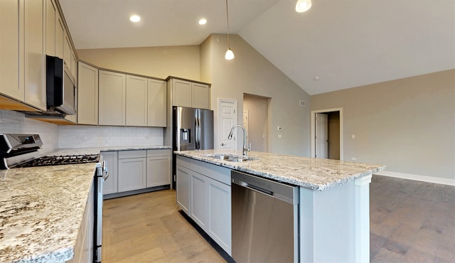 kitchen featuring stainless steel appliances, backsplash, high vaulted ceiling, sink, and a kitchen island with sink