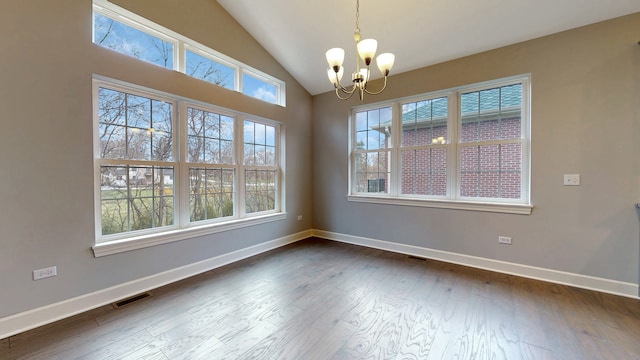 empty room featuring lofted ceiling, a chandelier, and dark wood-type flooring