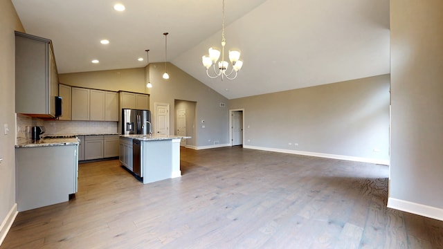 kitchen featuring a center island, hardwood / wood-style floors, decorative light fixtures, backsplash, and stainless steel refrigerator with ice dispenser