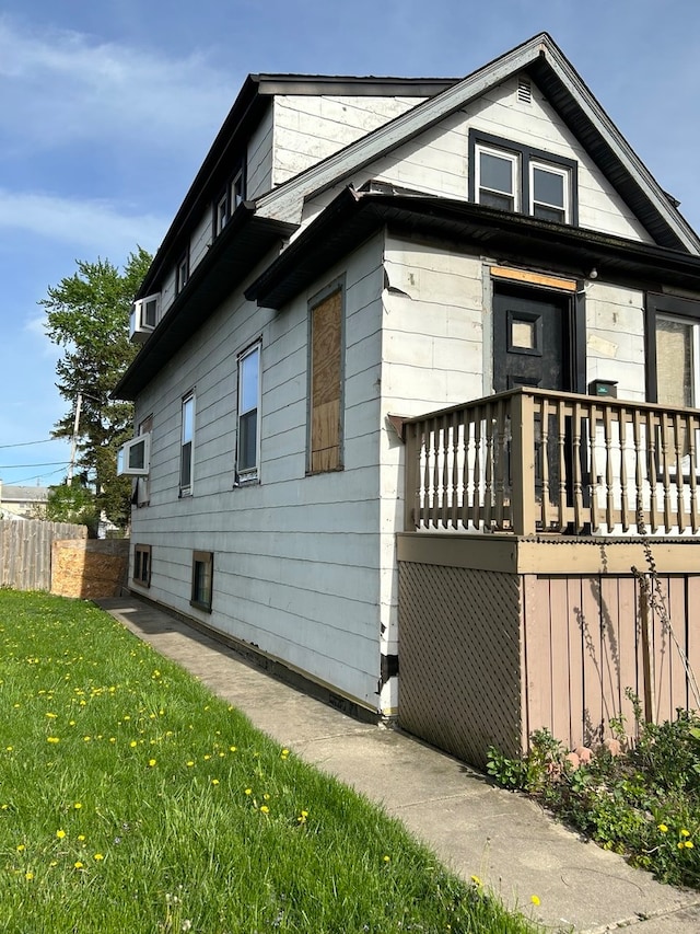 view of side of property with a yard and a wooden deck