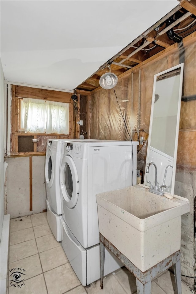 clothes washing area featuring separate washer and dryer, sink, and light tile floors