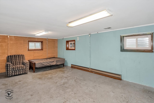 interior space with concrete floors, a baseboard heating unit, and multiple windows