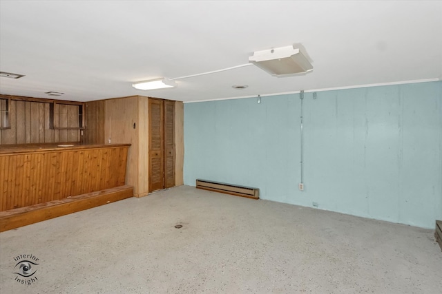 interior space with a baseboard radiator and wood walls