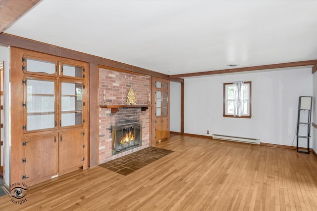 unfurnished living room with a baseboard heating unit, light hardwood / wood-style flooring, a fireplace, and brick wall