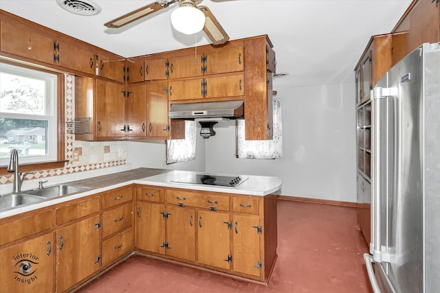 kitchen featuring black electric stovetop, high end refrigerator, sink, tasteful backsplash, and ceiling fan