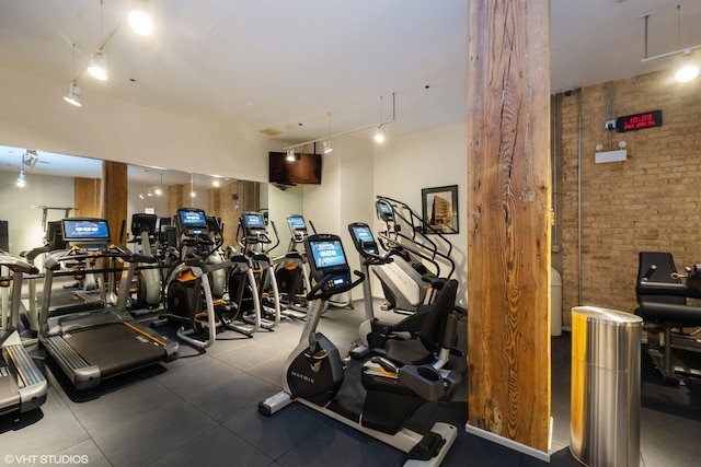 workout area featuring tile floors and brick wall