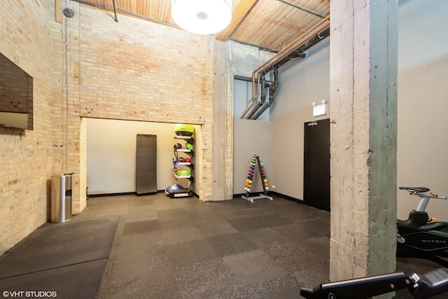 exercise area with brick wall and a high ceiling