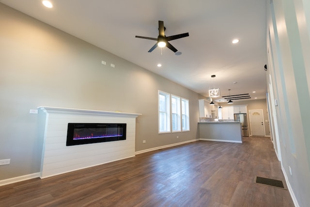 unfurnished living room with ceiling fan and dark wood-type flooring