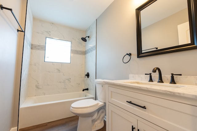 full bathroom with wood-type flooring, vanity with extensive cabinet space, toilet, and tiled shower / bath combo