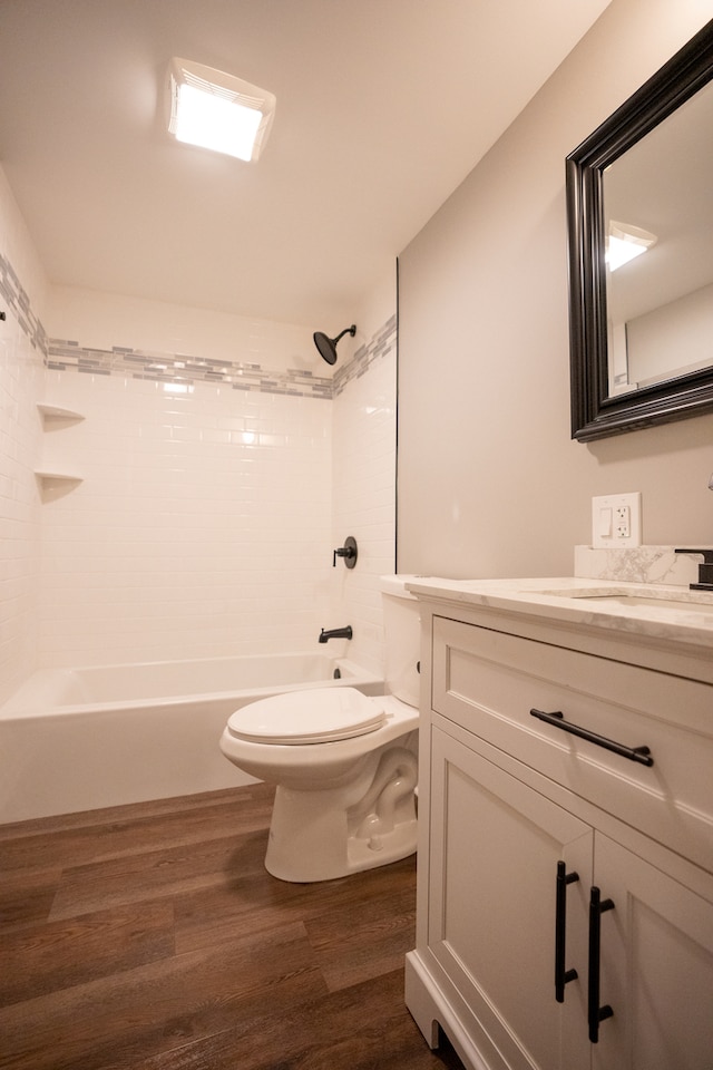 full bathroom with tiled shower / bath, hardwood / wood-style flooring, toilet, and vanity