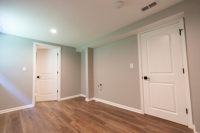 basement with dark hardwood / wood-style floors