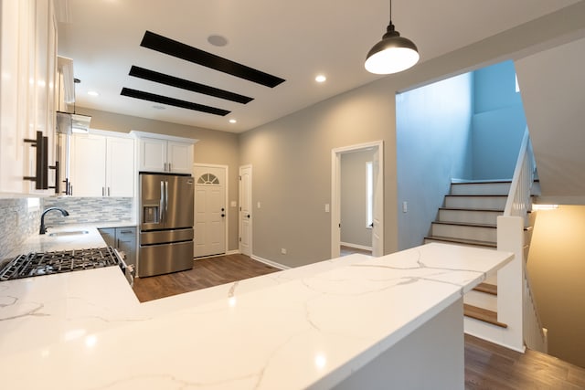 kitchen with stainless steel fridge with ice dispenser, dark hardwood / wood-style flooring, decorative light fixtures, sink, and tasteful backsplash