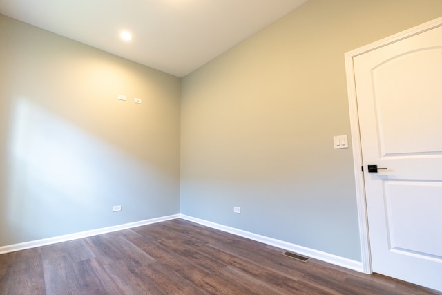 unfurnished room featuring vaulted ceiling and dark hardwood / wood-style flooring