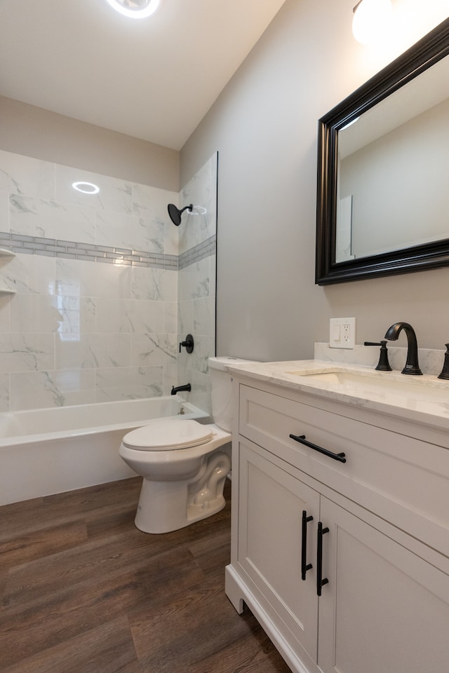 full bathroom featuring tiled shower / bath, vanity, toilet, and wood-type flooring