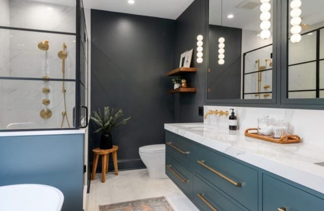 bathroom featuring tile patterned floors, toilet, tiled shower, decorative backsplash, and vanity