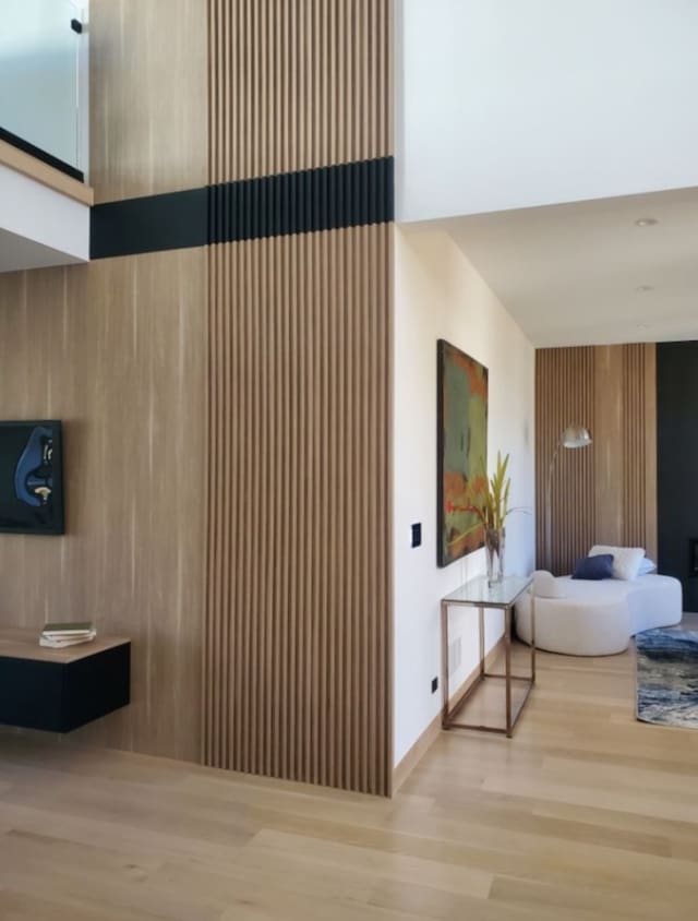 interior space featuring light wood-type flooring and wooden walls