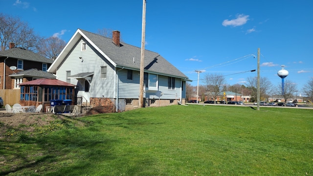 rear view of property featuring a lawn